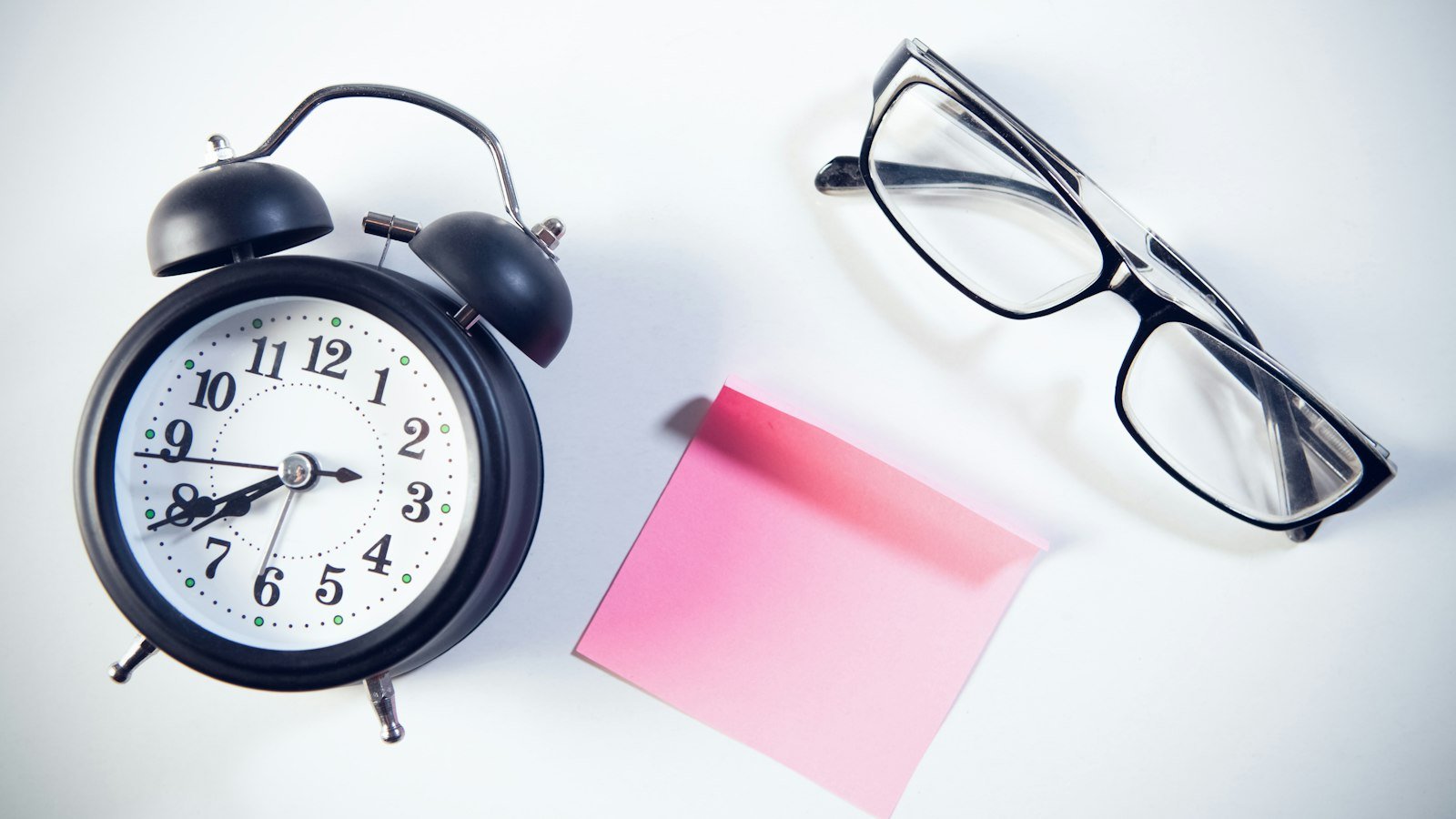 Alarm clock and sticky note as a deadline reminder